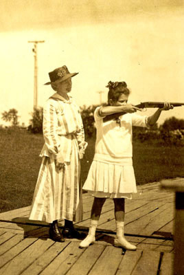 Annie Oakley watches as young girl takes aim