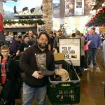 Tim holding his Muck Boots in Cabelas, Charlie is sniffing the toe