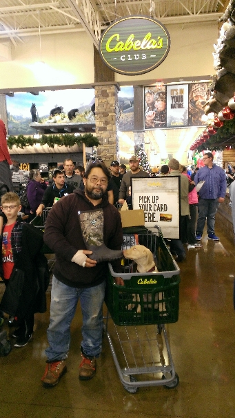 Tim holding his Muck Boots in Cabelas, Charlie is sniffing the toe